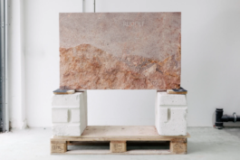 Grabstein auf Stützen in der Werkstatt mit vollständiger Steinplatte und Relief vor der Aufstellung