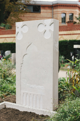 Completed gravestone installed outdoors, viewed from a slight angle in the cemetery